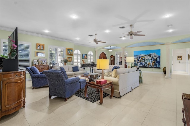 tiled living room with vaulted ceiling, ornamental molding, ceiling fan, and ornate columns