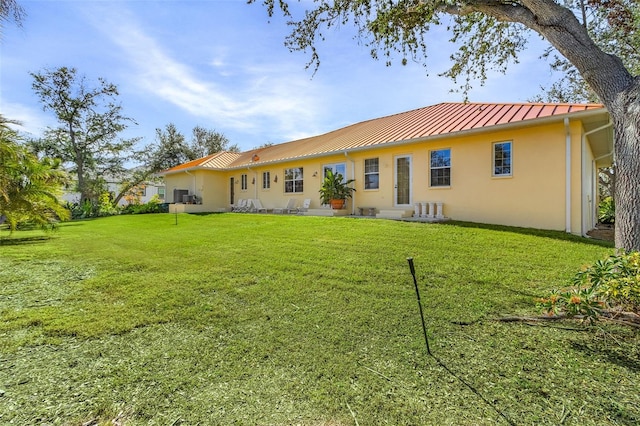 rear view of house featuring a lawn