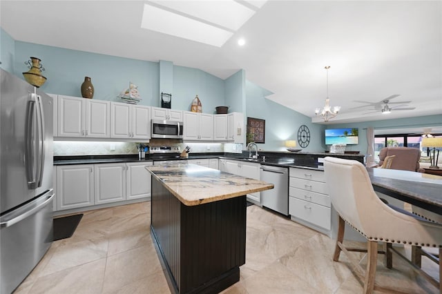 kitchen with white cabinetry, sink, hanging light fixtures, a center island, and stainless steel appliances