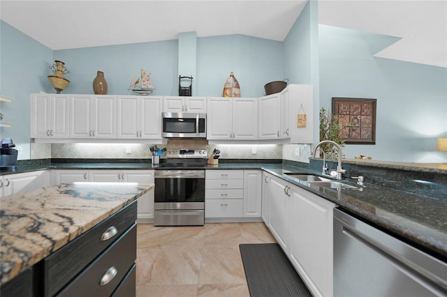 kitchen with dark stone countertops, sink, white cabinets, and appliances with stainless steel finishes