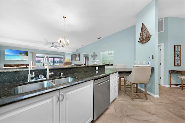 kitchen with sink, decorative light fixtures, stainless steel dishwasher, dark stone counters, and white cabinets