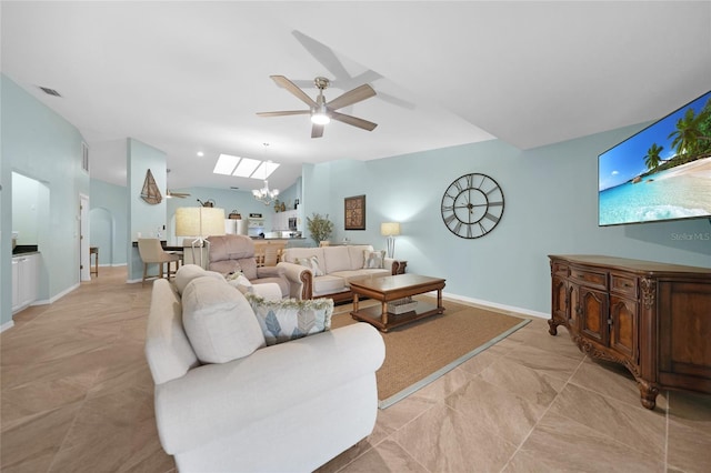 living room with lofted ceiling and ceiling fan with notable chandelier