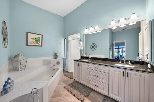 bathroom featuring vanity, a relaxing tiled tub, and tile patterned floors