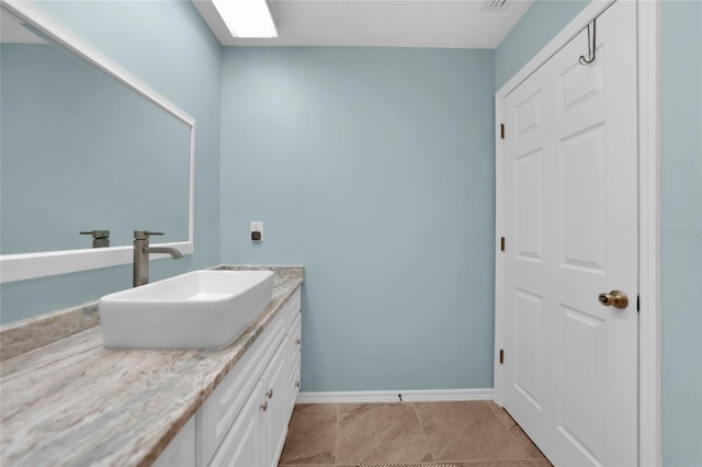 bathroom featuring tile patterned floors, a skylight, and vanity