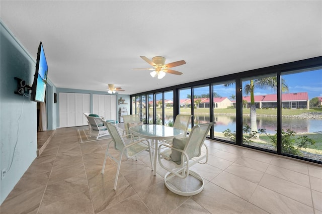 unfurnished sunroom featuring a water view and ceiling fan