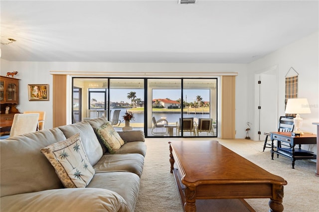 carpeted living room with a water view