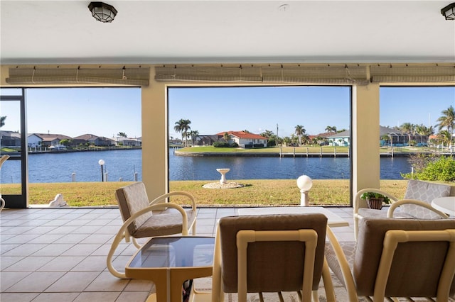 sunroom featuring a wealth of natural light and a water view