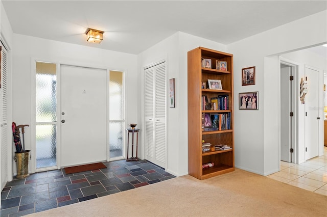 foyer entrance with dark colored carpet