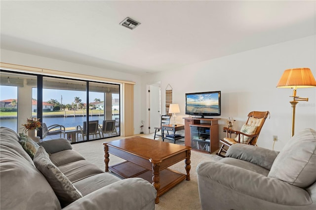 living room featuring a water view and light colored carpet