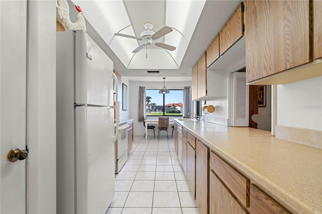 kitchen featuring light tile patterned flooring, sink, ceiling fan, pendant lighting, and white appliances