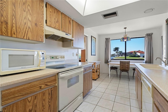 kitchen featuring light tile patterned flooring, sink, pendant lighting, and white appliances