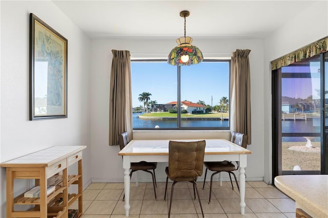 tiled dining room featuring a water view