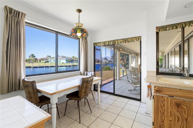 tiled dining space with a water view and sink