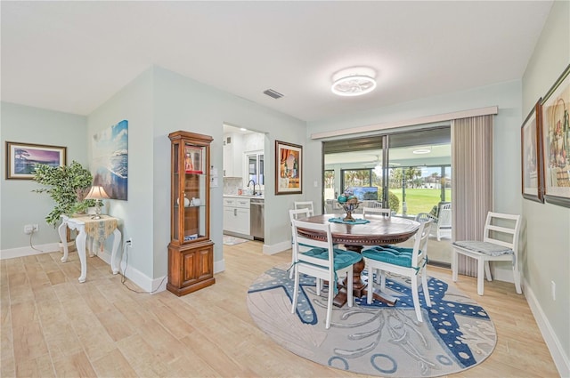 dining room with sink and light hardwood / wood-style floors