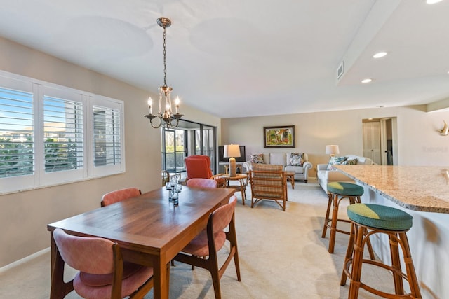 carpeted dining room with a chandelier