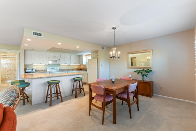 dining room with an inviting chandelier and light colored carpet