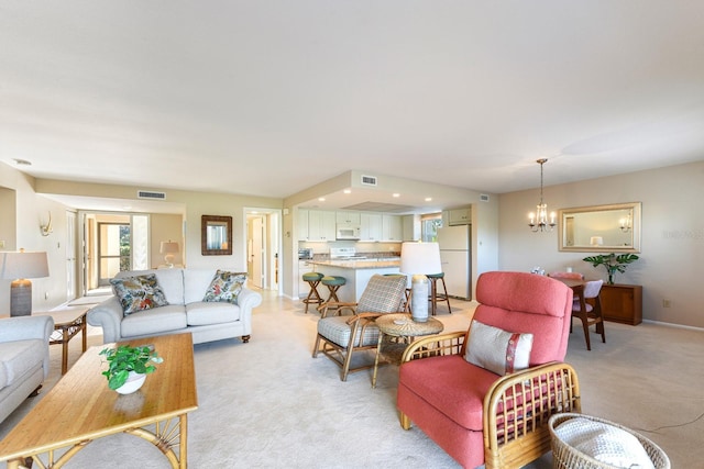 living room with light carpet and a notable chandelier