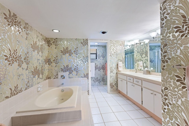 bathroom with tile patterned flooring, vanity, and tiled bath