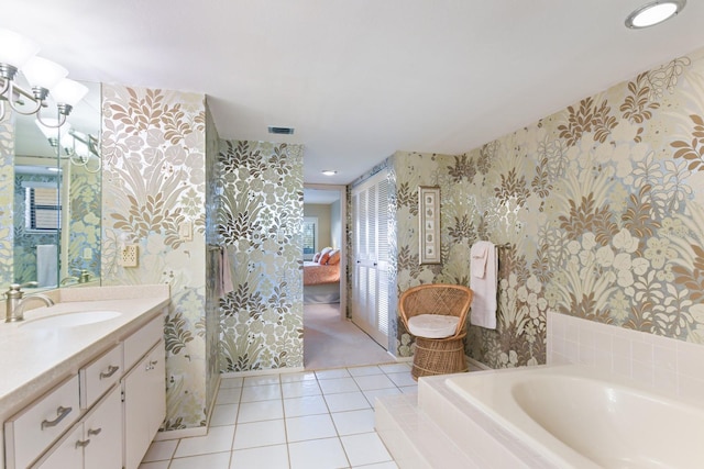 bathroom with vanity, tiled bath, and tile patterned flooring