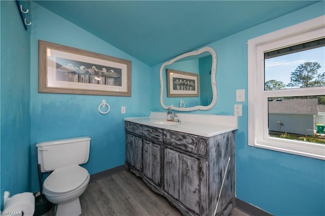 bathroom featuring lofted ceiling, toilet, wood-type flooring, and vanity