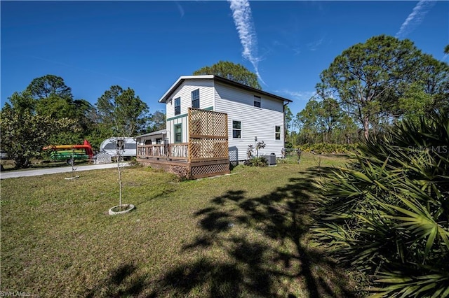 view of property exterior with a wooden deck and a lawn