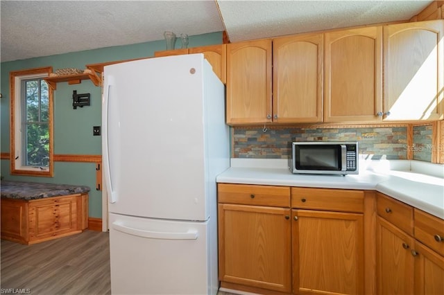 kitchen with tasteful backsplash, dark hardwood / wood-style floors, a textured ceiling, and white refrigerator