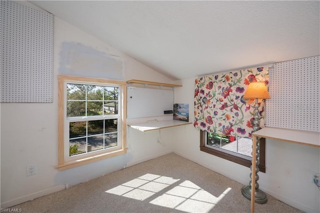 kitchen featuring light colored carpet and vaulted ceiling