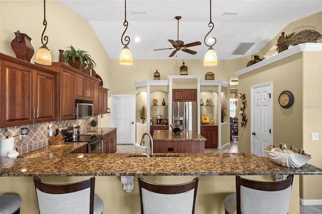 kitchen featuring lofted ceiling, stainless steel appliances, decorative light fixtures, and decorative backsplash