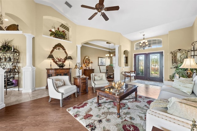 living room with vaulted ceiling, decorative columns, and hardwood / wood-style flooring