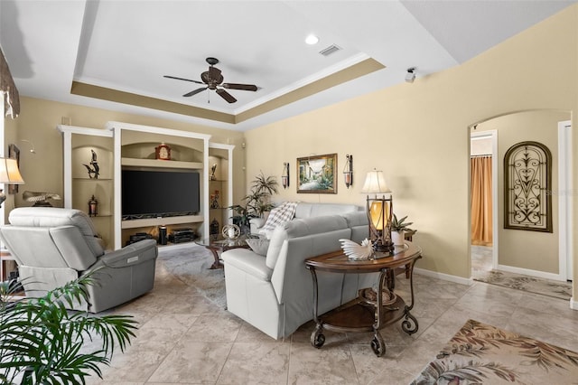 living room with crown molding, ceiling fan, and a raised ceiling