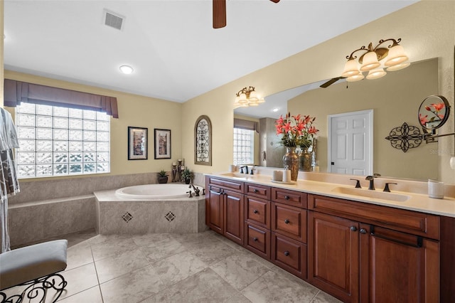 bathroom with vanity, tiled bath, and ceiling fan