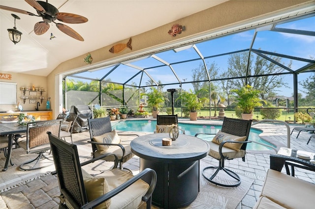 view of patio / terrace featuring sink, ceiling fan, and glass enclosure