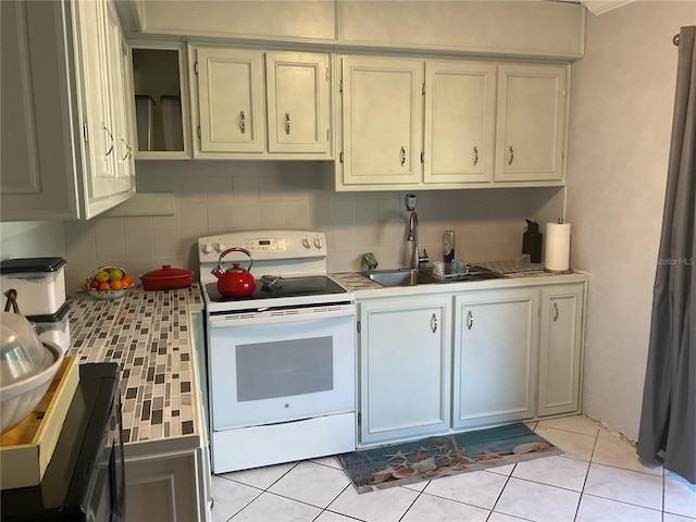 12077 Maryland Ave, Punta Gorda, FL 33955 - kitchen with light tile patterned flooring, white electric range, sink, and tasteful backsplash