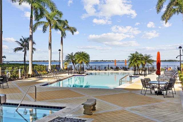 view of swimming pool with a patio and a water view