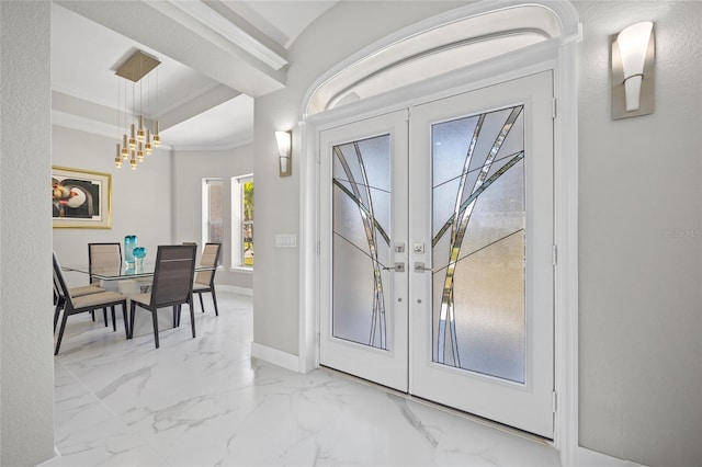3415 Tripoli Blvd, Punta Gorda, FL 33950 - foyer entrance with an inviting chandelier, french doors, and crown molding