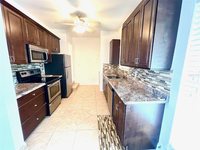 kitchen with backsplash, stainless steel appliances, sink, and light tile patterned floors