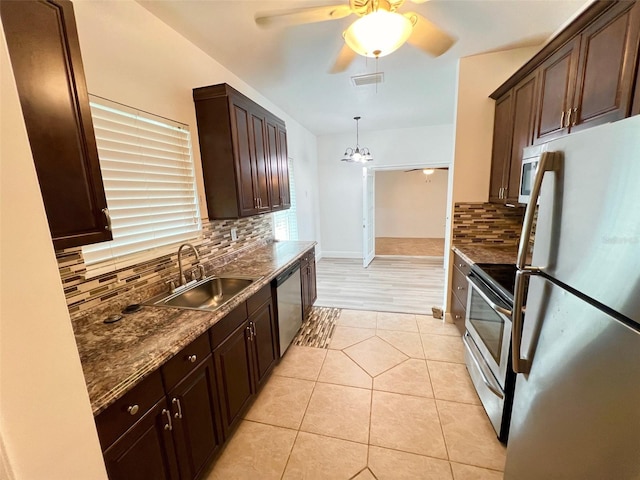 kitchen featuring sink, light tile patterned floors, ceiling fan, appliances with stainless steel finishes, and decorative light fixtures