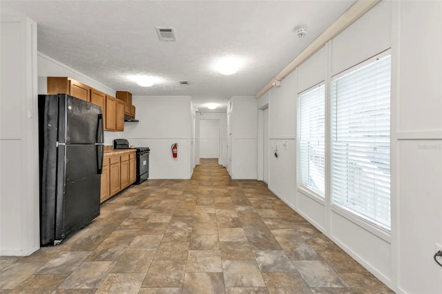 kitchen with a textured ceiling and black appliances