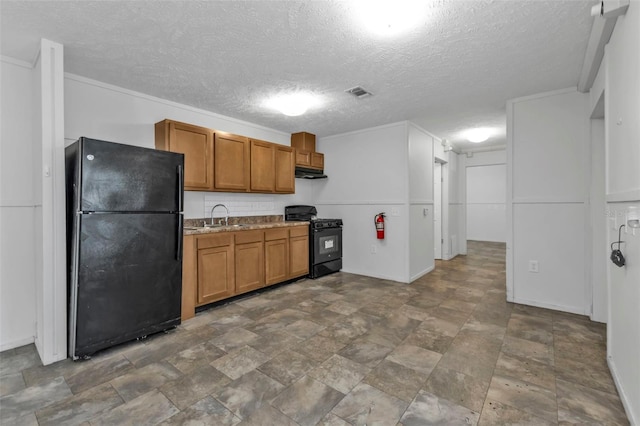 kitchen with sink, a textured ceiling, and black appliances