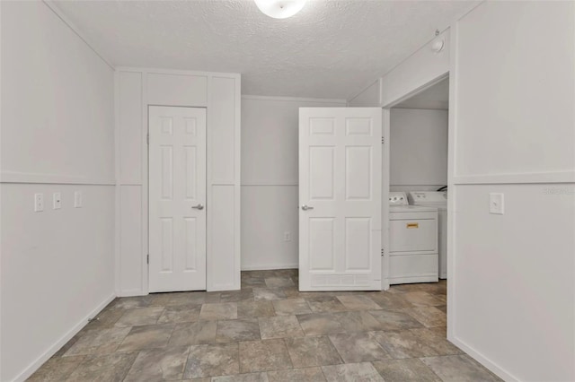 unfurnished bedroom with washer and dryer and a textured ceiling