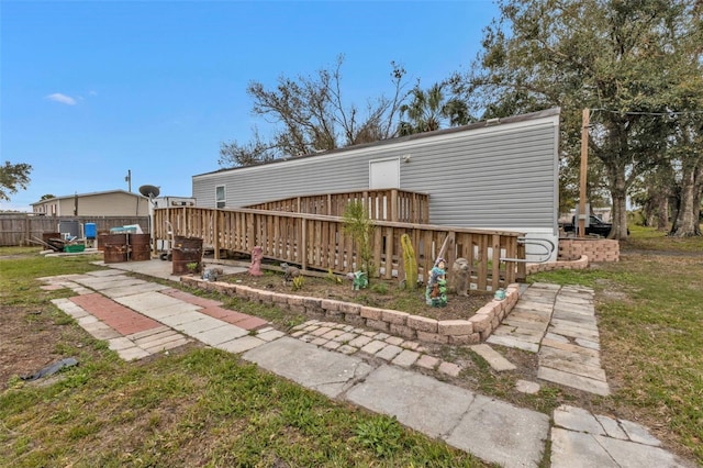 back of house with a wooden deck and a yard