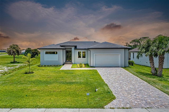 prairie-style home with a garage and a lawn