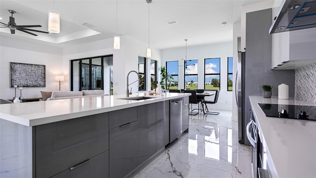 kitchen with a large island, stainless steel appliances, decorative light fixtures, and sink