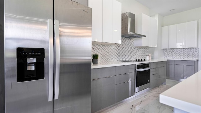 kitchen featuring white cabinetry, appliances with stainless steel finishes, gray cabinets, and wall chimney range hood