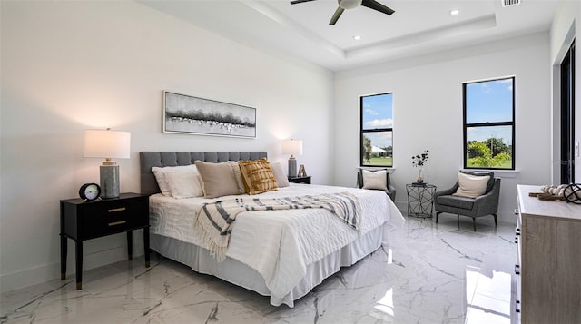 bedroom with ceiling fan and a tray ceiling