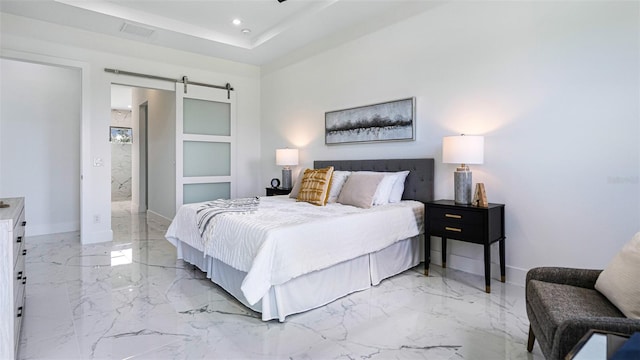 bedroom featuring a barn door and connected bathroom