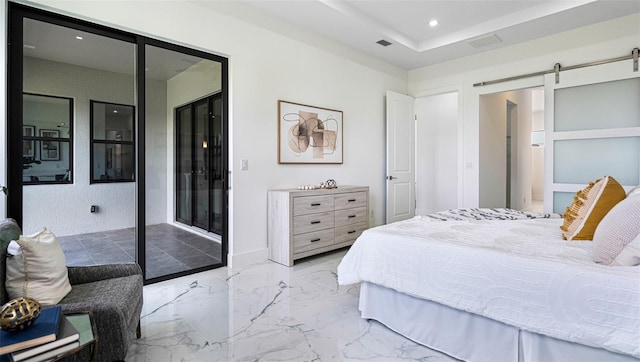 bedroom with a tray ceiling, a barn door, and access to exterior