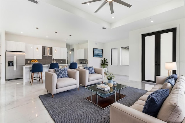 living room featuring a raised ceiling and ceiling fan