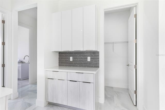 kitchen featuring tasteful backsplash and white cabinets