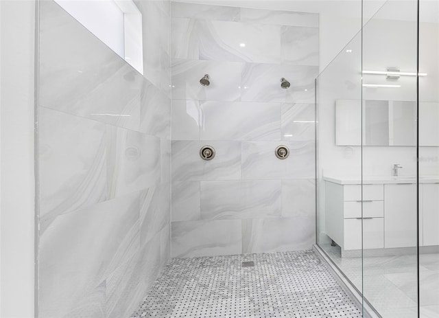 bathroom with vanity and a tile shower